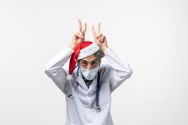 药品正面图白色办公桌上戴着无菌口罩的男医生新年病毒大流行工作制服圣诞节