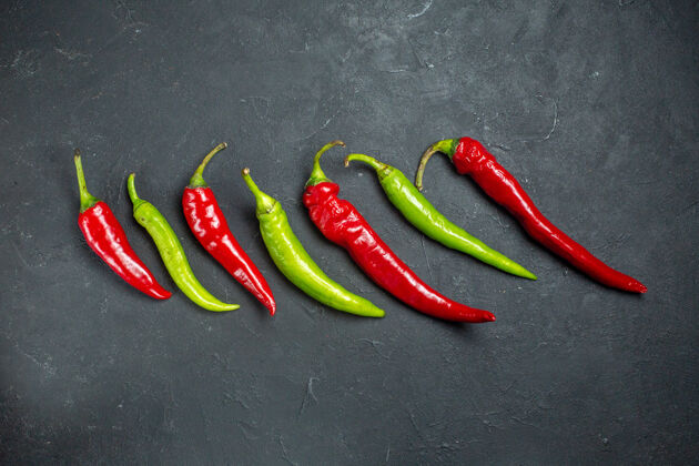 辣椒顶视图水平行绿色和红色辣椒在黑暗的表面与自由的地方新鲜配料绿色和红色辣椒
