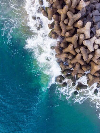 浪垂直俯视空中拍摄的波浪蓝色的海洋对岩石海岩石自然