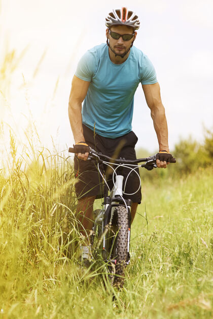 自行车骑着自行车穿过草地的人男人运动设备草地