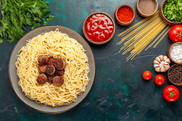 桌子蓝色桌面上的意大利熟面食 有肉丸子和不同的调味品饮食配料健康