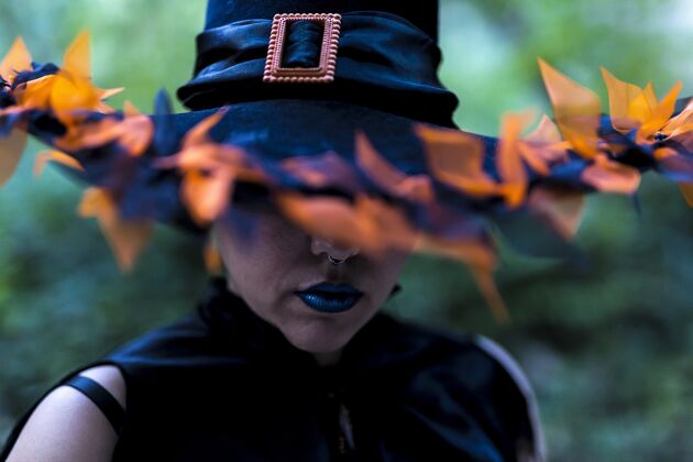 恐惧一个女人穿着女巫的化妆和服装 戴着一顶装饰过的帽子 在森林里被抓获性感漂亮头发