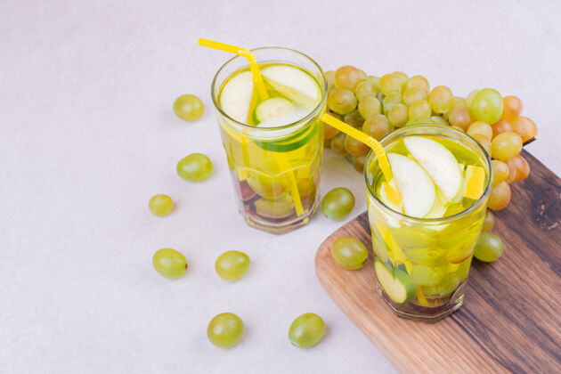 产品绿葡萄和两杯果汁放在木板上健康饮料质量