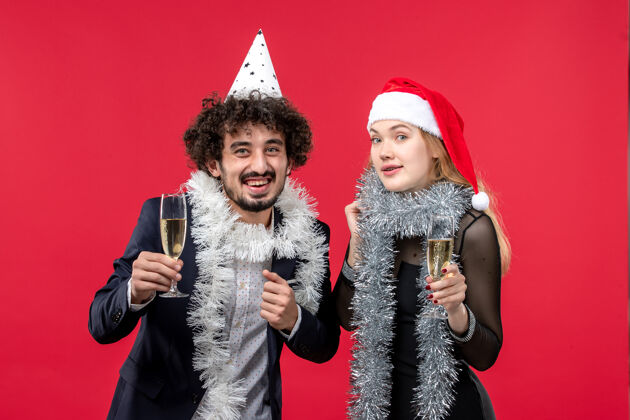 庆祝正面图：年轻夫妇在红桌爱心圣诞派对上庆祝新年服装衣服风景