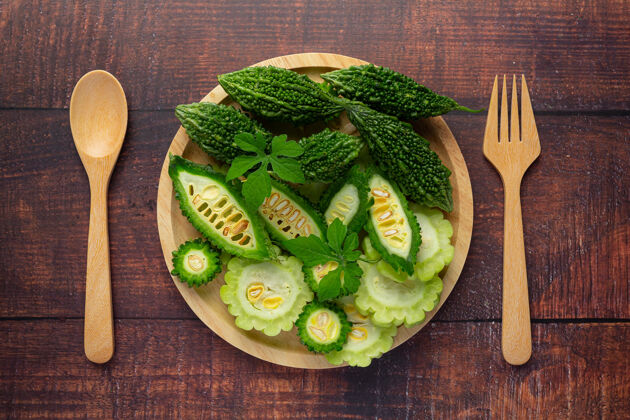静止用勺子和叉子把剁碎的苦瓜放在木盘上健康食用健康