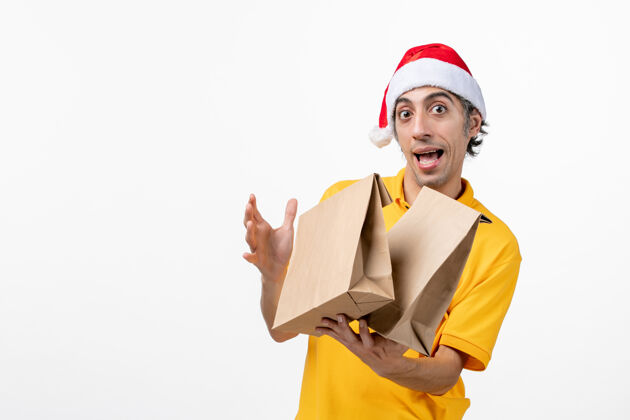 圣诞节正面图男快递员用白色地板上的食品包裹服务制服送货服务职业头盔