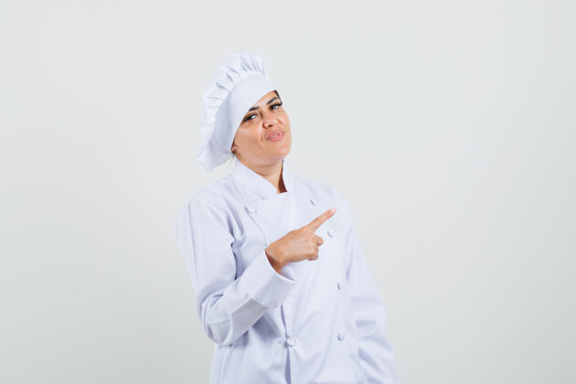 亚洲身着白色制服的女厨师指指点点 看上去很自信帽子职业厨师