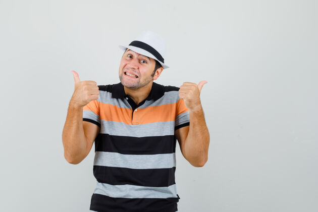 衬衫一个年轻人穿着t恤 戴着一顶大拇指朝上的帽子 看上去很快乐帽子向上男人