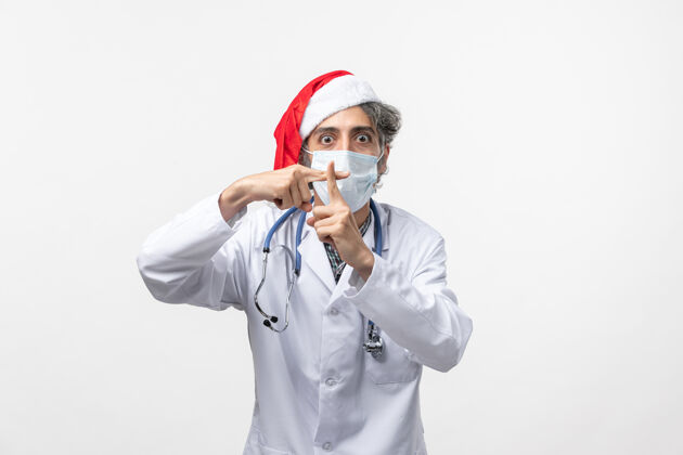 冠状病毒正面图男医生在无菌口罩上白墙病毒共济新年假期病毒电话电话