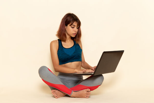 笔记本电脑年轻女性穿着蓝色衬衫 在白色墙上使用笔记本电脑 身体健康锻炼漂亮人
