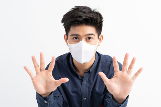 传播停止civid-19 亚洲男子戴口罩显示停止手势 停止电晕病毒爆发病毒停止手病毒传播
