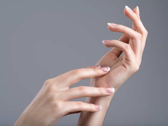 人类美丽的女性手 指甲上有法式美甲优雅手抛光