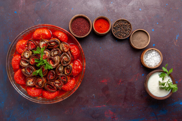烹饪俯瞰烹饪蔬菜餐美味的西红柿和茄子与调味品在黑暗的表面顶部调味品勺子