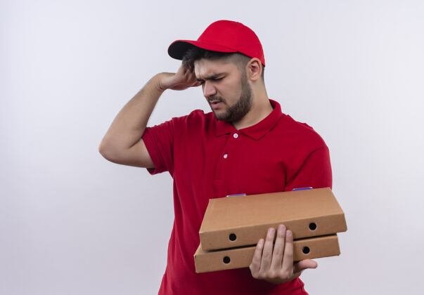 盒子年轻的送货员身穿红色制服 头戴鸭舌帽 手里拿着披萨盒 看上去很疲惫 工作过度 头上有强烈的头痛强壮送货抱着