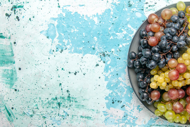 蓝莓顶部近距离观看新鲜的彩色葡萄多汁和醇厚的水果在蓝色的表面可食用的水果新鲜葡萄