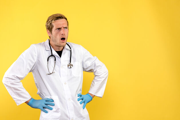 视图正面图黄色背景上的男医生混淆了健康医学人病毒前面制服病毒