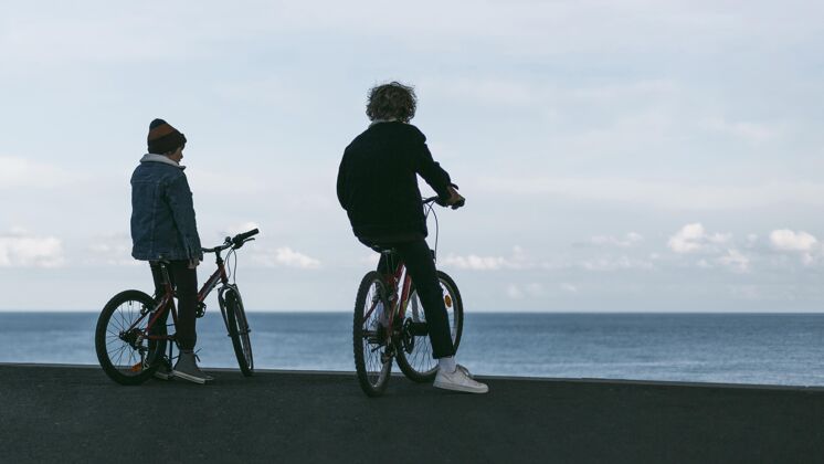娱乐两个男孩带着自行车和复印空间在城市户外活跃青年自行车