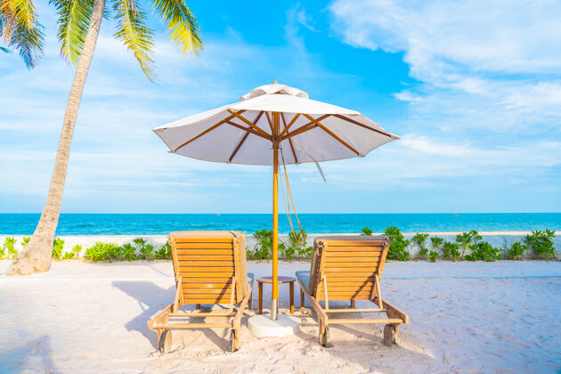 度假村酒店度假区的户外游泳池周围有雨伞和躺椅 有海边沙滩和椰子树别墅景观水