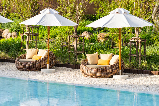 游泳酒店度假区的户外游泳池周围有雨伞和躺椅 有海边沙滩和椰子树海滩户外海洋