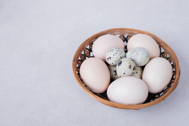 有机鹌鹑蛋和鸡蛋放在白色的碗里视图天然新鲜