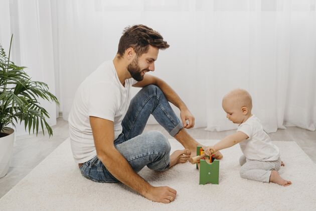 父亲爸爸和宝宝一起在家玩耍的侧视图父母父亲团结