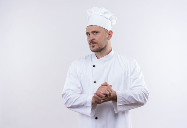 体贴体贴的年轻帅哥厨师穿着厨师制服 手放在一片空白处一起厨师手