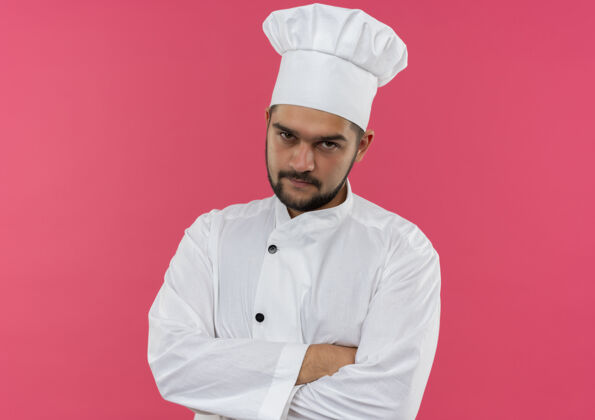 复制体贴的年轻男性厨师身着厨师制服 站在粉红色的空间里 封闭的姿势看起来很孤立制服年轻厨师
