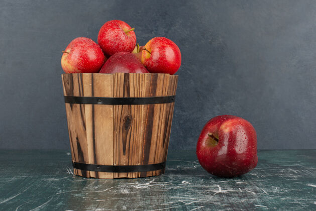 水滴红苹果从桶里掉在大理石桌上多汁苹果有机