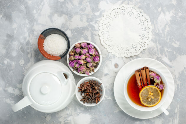晚餐顶视图一杯茶 白色表面上有鲜花和水壶杯子食物甜食
