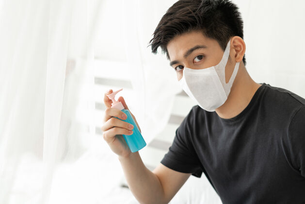酒精在隔离室里 一个戴着口罩的亚洲人拿着酒精洗手 以保护冠状病毒冠状病毒-19诊所生病健康护理
