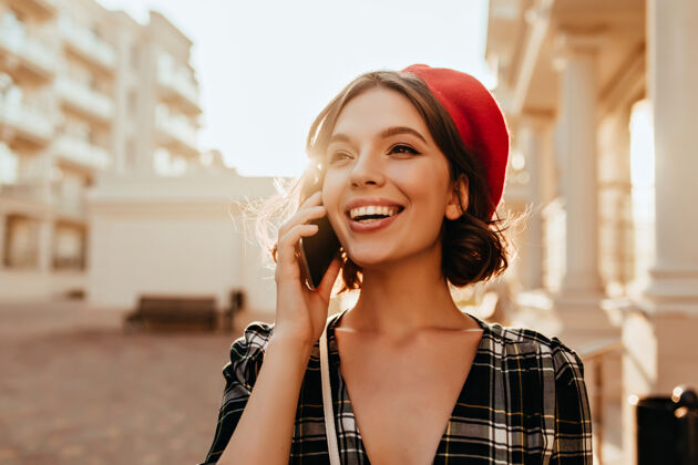 法国女人穿着时髦贝雷帽的温文尔雅的白种女人在打电话浪漫的法国女孩带着欢快微笑的户外照片年轻微笑法国