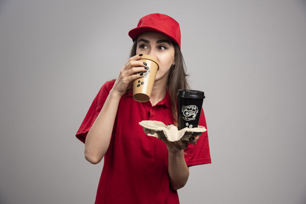 快递穿着红制服喝咖啡的漂亮女送货员员工饮料女孩
