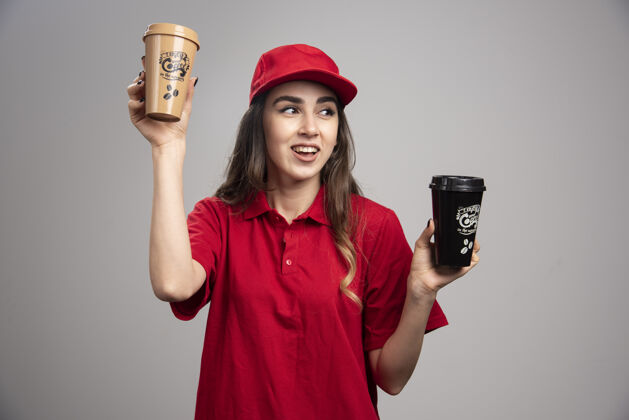 送货穿着红色制服拿着咖啡杯的女送货员人饮料女性