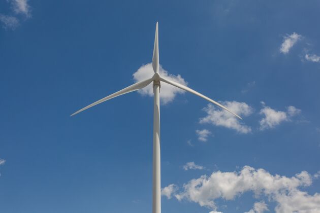 能源低角度拍摄阳光下的风车和白天的蓝天-环境概念设备生态替代