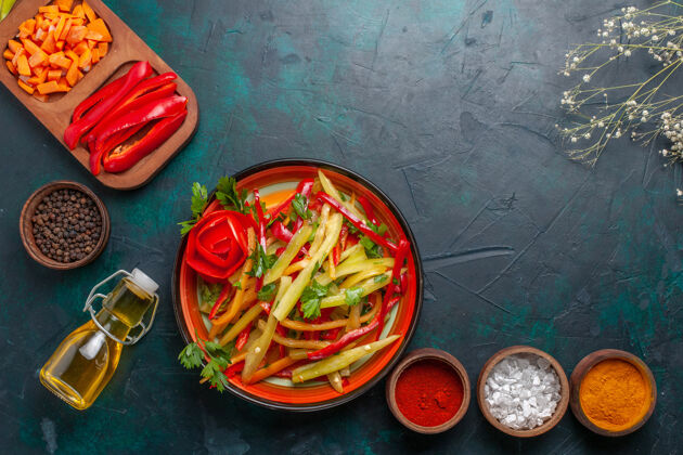 铃铛顶视图切甜椒与调味品沙拉和油蓝色背景油蔬菜背景