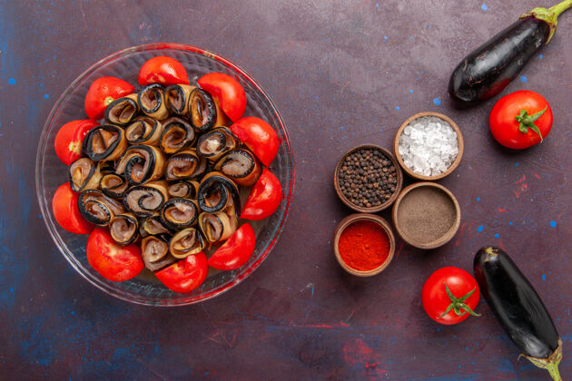 一餐俯视图蔬菜餐切片和卷西红柿与茄子和调味品在黑暗的背景烹饪咖啡