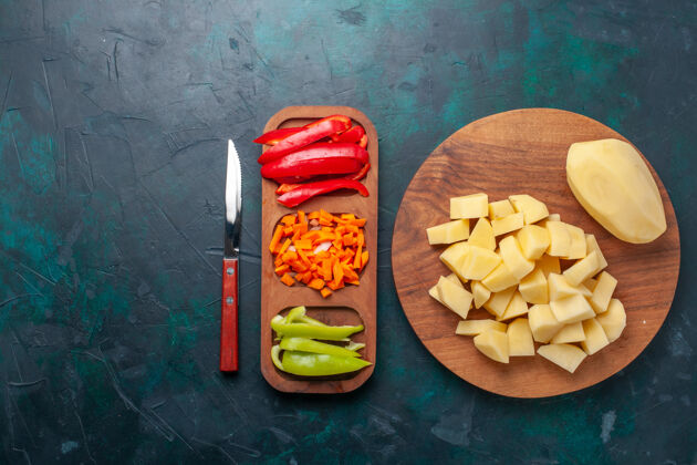 晚餐顶视图深蓝色背景上的新鲜土豆片和辣椒片健康背景小吃