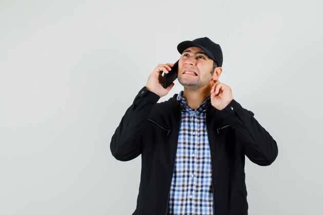 手机穿着衬衫 夹克 帽子的年轻人在讲手机时听力不好男人谈话男性