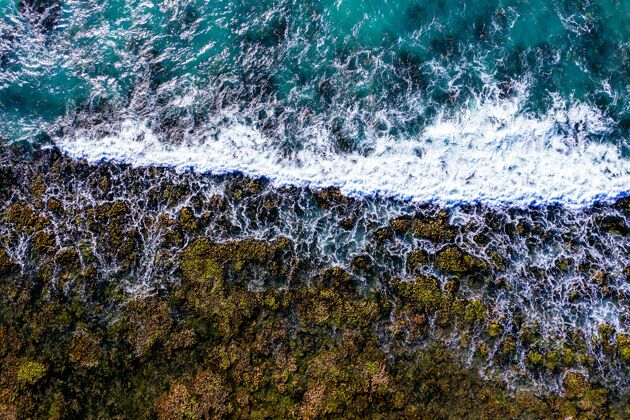背景空中拍摄的岩石海岸泡沫波水海边海岸
