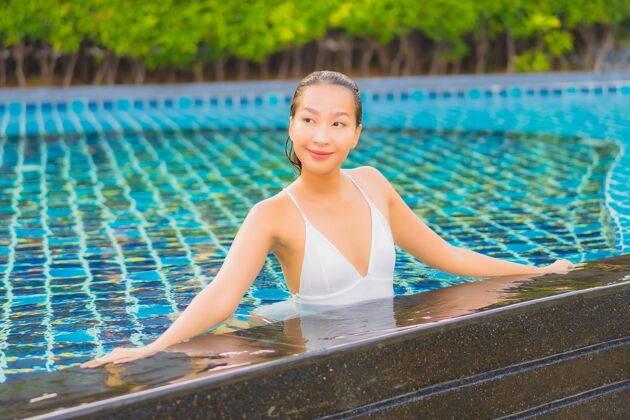 阳光肖像美丽的亚洲年轻女子放松微笑休闲围绕室外游泳池近海年轻人放松健康