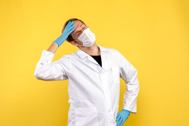 人黄底健康冠状病毒大流行头痛男医生正面图流行视图实验室外套