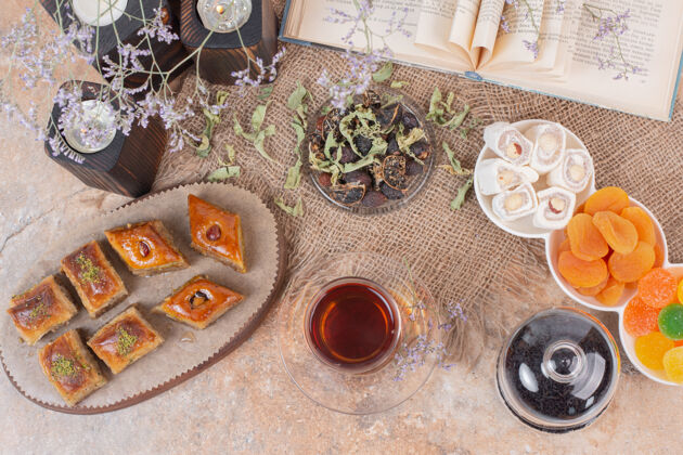 文化在大理石桌上放一杯茶 糖果和传统的各种烤肉Baklava干视图