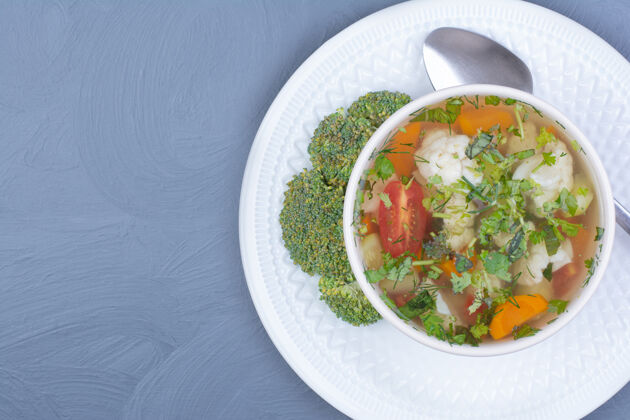 膳食在一个白色的杯子里放蔬菜和香草的西兰花汤肉汤切碎顶部