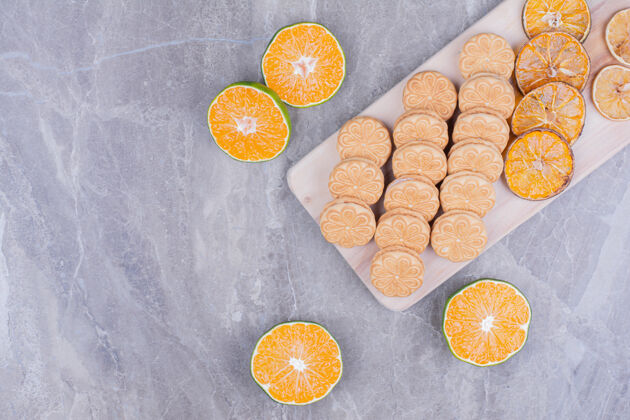 饼干放在木板上的饼干 周围是橘子片香草地壳甜点