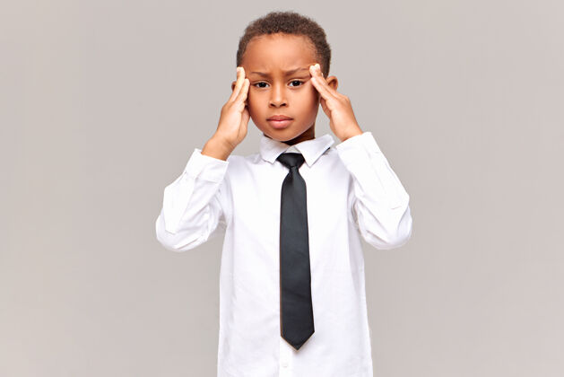 焦虑人类的反应 情感和态度受挫不开心的非洲学生穿着校服按摩太阳穴 头痛 家庭作业压力大孩子非洲头痛