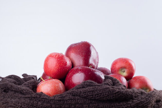成熟棕色布料上有四个红苹果苹果吃滴