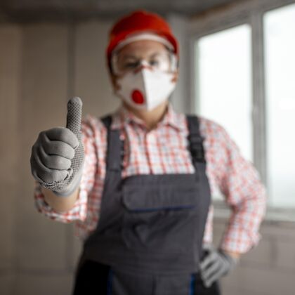 竖起大拇指戴着头盔和面罩竖起大拇指的女建筑工人劳动者专业知识职业