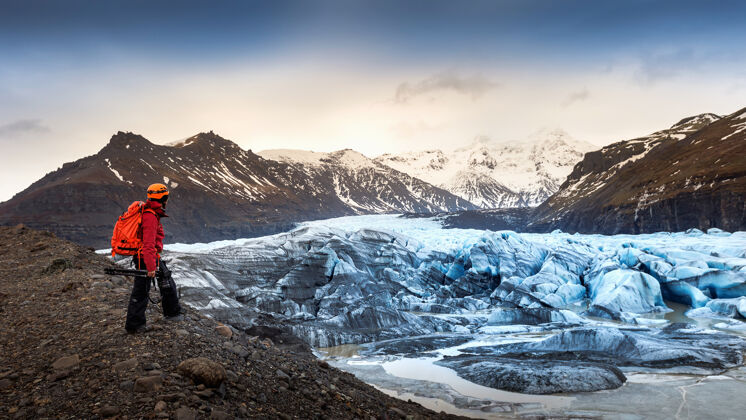 天空专业摄影师用相机和三脚架在冬天专业摄影师期待在冰岛冰川风景冬天水