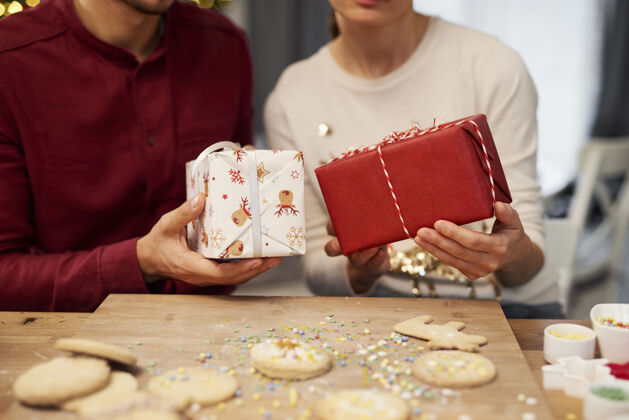国内厨房一对夫妇拿着圣诞礼物和饼干的特写镜头成人配料关闭