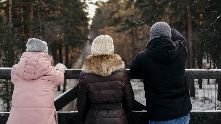 女人冬天户外朋友群的背影乐趣在一起休闲